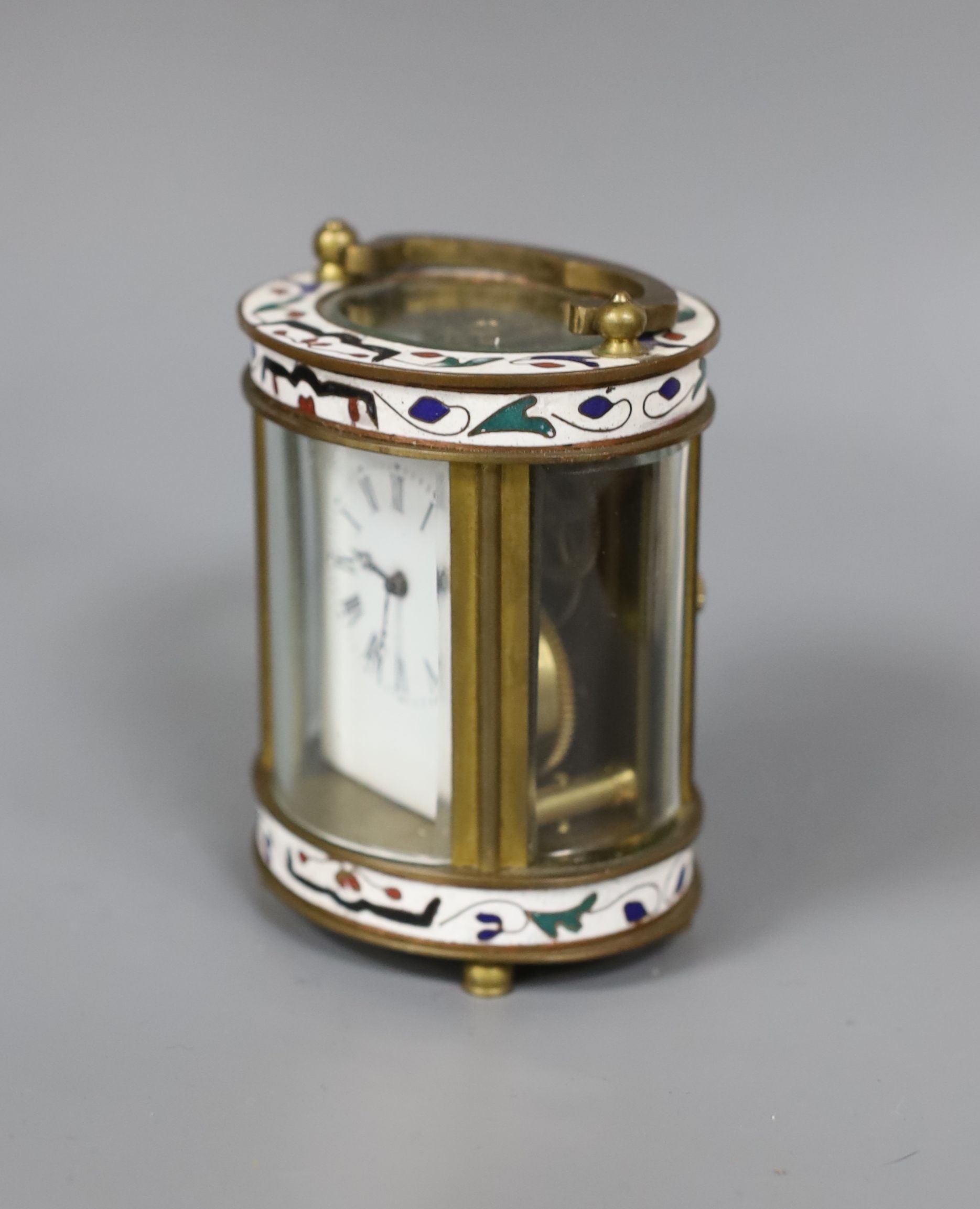 An oval brass and champleve enamel carriage timepiece, 9cm